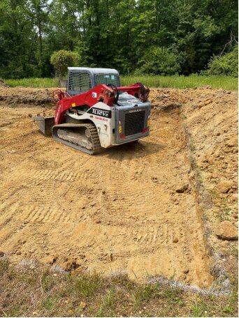 Skid steer grading the building pad
