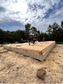 Crew laying the subfloor over the new foundation