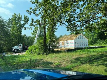 Crane setting roof trusses on a framed home