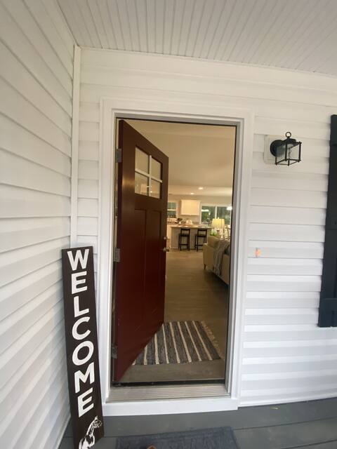 Front porch with welcome mat and red front door