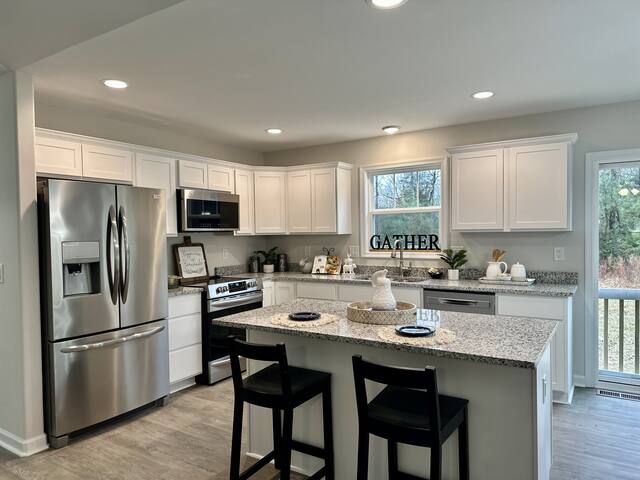 Kitchen with white shaker cabinets and island seating