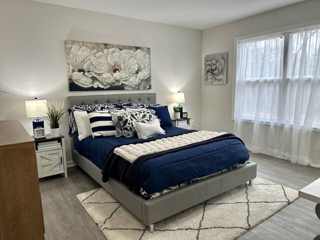 Staged primary bedroom with navy bedding